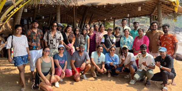 Abstract Group team smiling infront of a hut