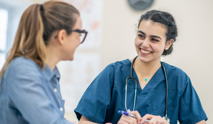 A female nurse sat with a female patient 