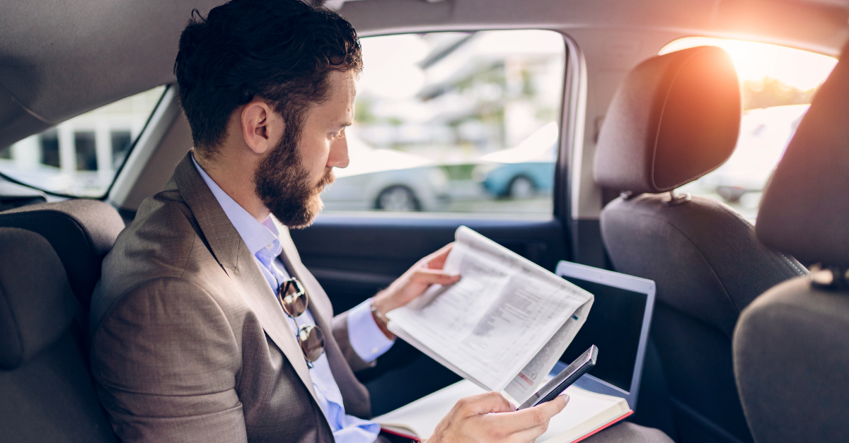 Man sat reading papers in a car