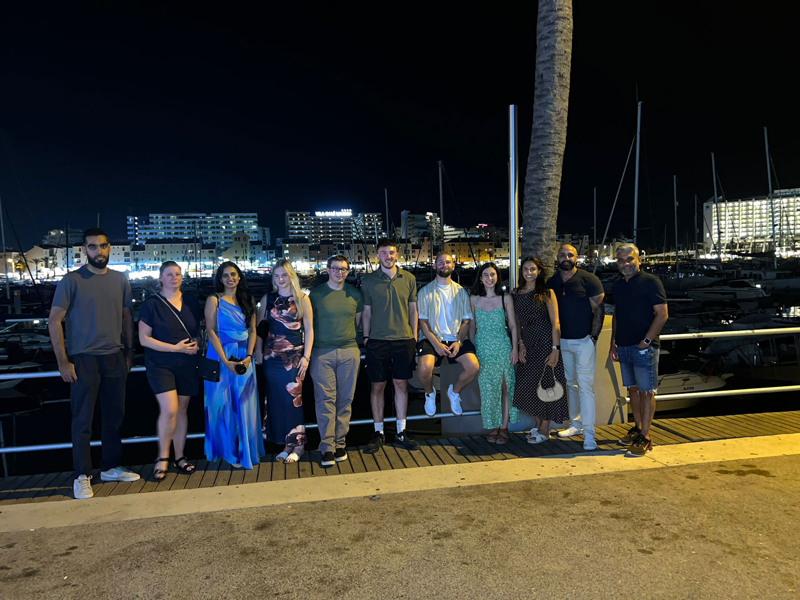 Our UK team, posing together at night by Vilamoura marina on our annual team-building trip